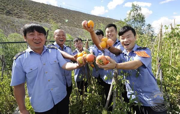 罕台川北站职工举起亲手种植的蔬菜高兴地示意.JPG